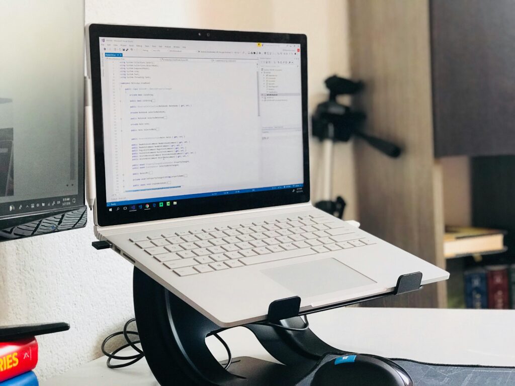 A home office setup featuring a laptop on a stand and a monitor, ideal for remote work.